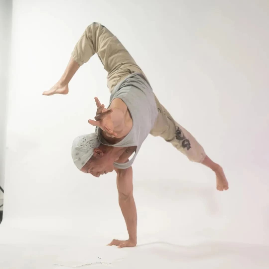 Un danseur en équilibre sur les mains, jambes pliées